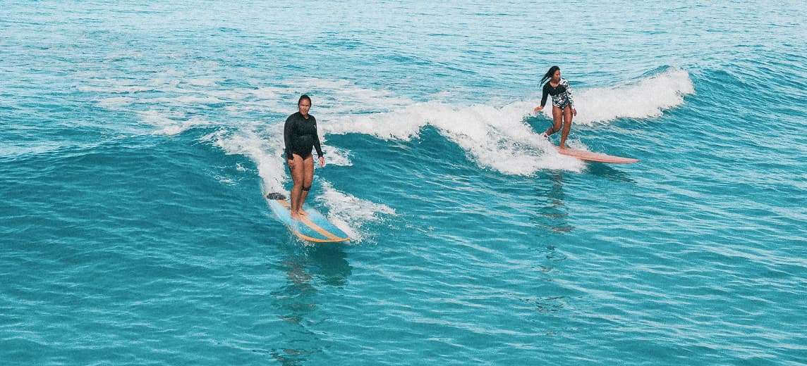Beginner surfers riding waves together at a surf retreat