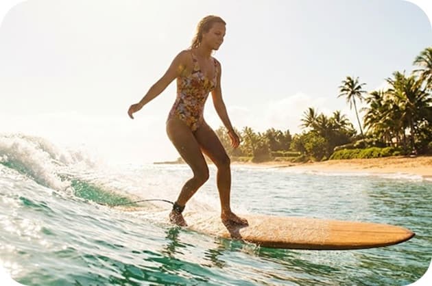 Surfer riding a wave near Uluwatu cliffs