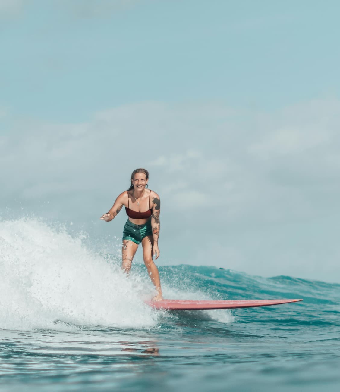 Longboard surfer riding a wave in turquoise water